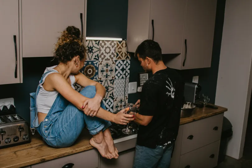 Leane sitting on the kitchen counter while Anru cooks