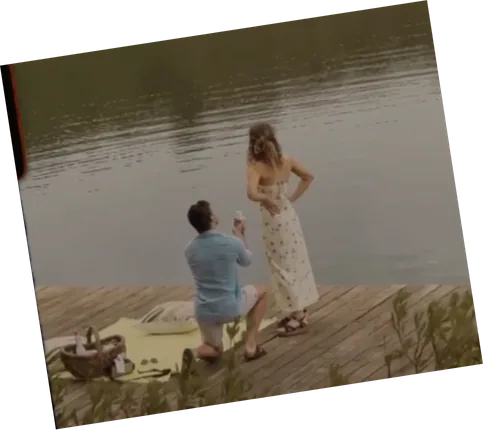 Anru on one knee on a jetty, proposing to Leane
